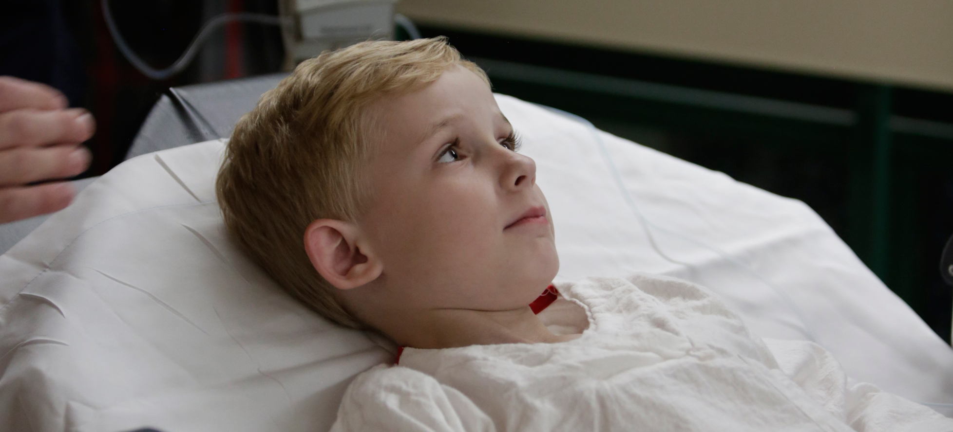 boy lying in hospital bed