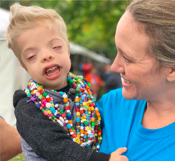 SickKids patient Jacob wearing his bravery beads as his mom holds him