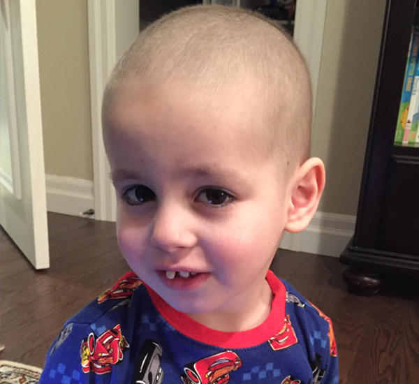 SickKids patient Marky smiling at home, wearing red pyjamas.