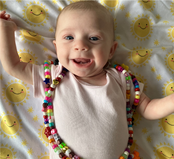  SickKids patient Zoe smiling at the camera with her bravery beads