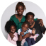 SickKids patient Maya with her mom, dad and sister. They are all smiling.