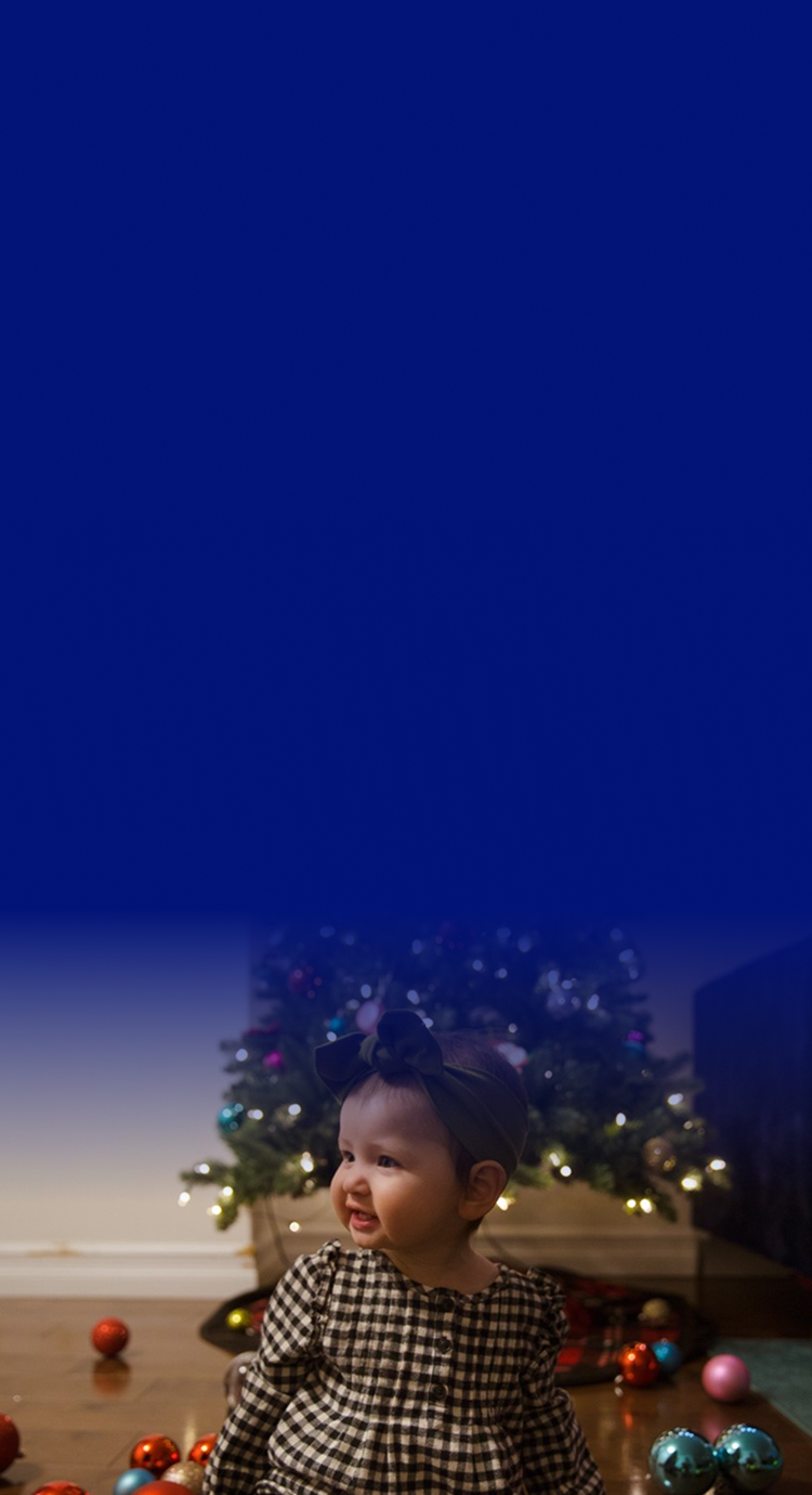 Nora sitting infront of christmas tree