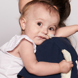 SickKids patient resting on mother's shoulder