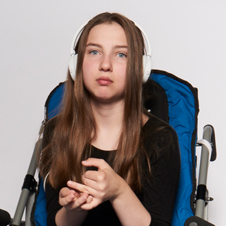 Teenage SickKids patient in wheelchair with headphones