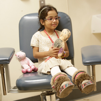 SickKids patient in hospital room holding doll