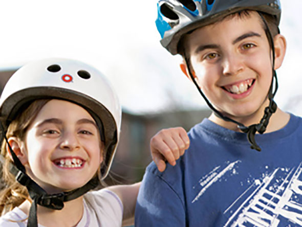 Two kids wearing bicycle helmets