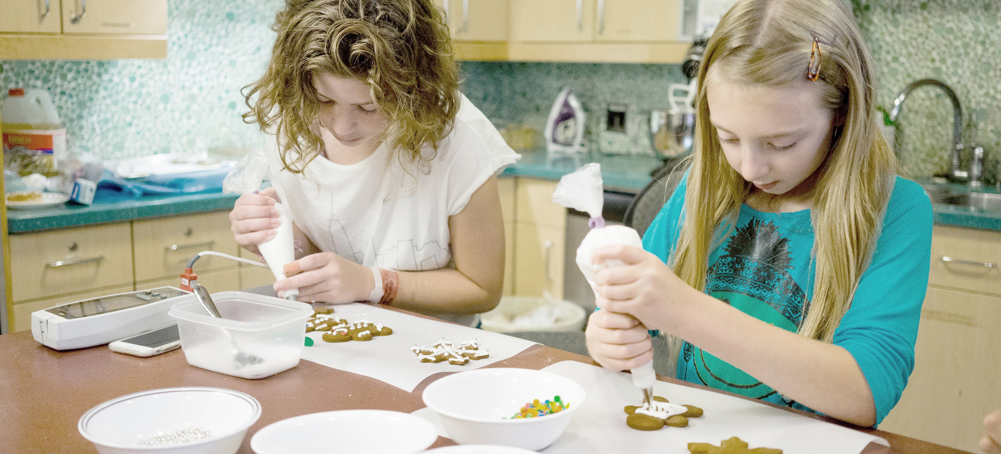 two girls decorating cookies