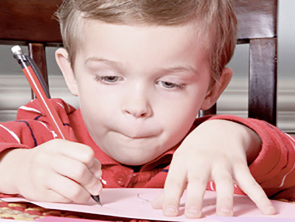Little boy drawing with a pencil