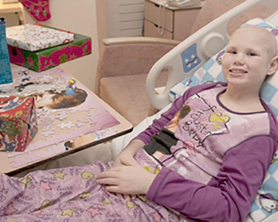 Girl in pajams lying in hospital bed