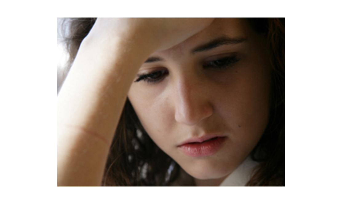 Girl looking down at floor with sad expression on her face