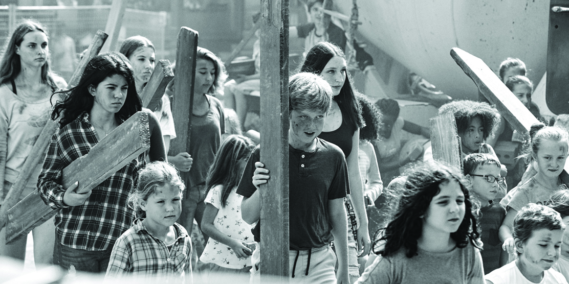 Black and White image of children carrying building materials