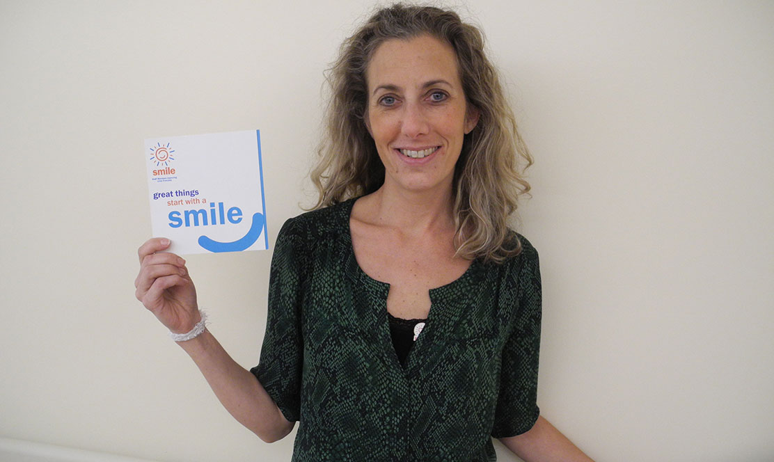 Staff member holding SMILE award