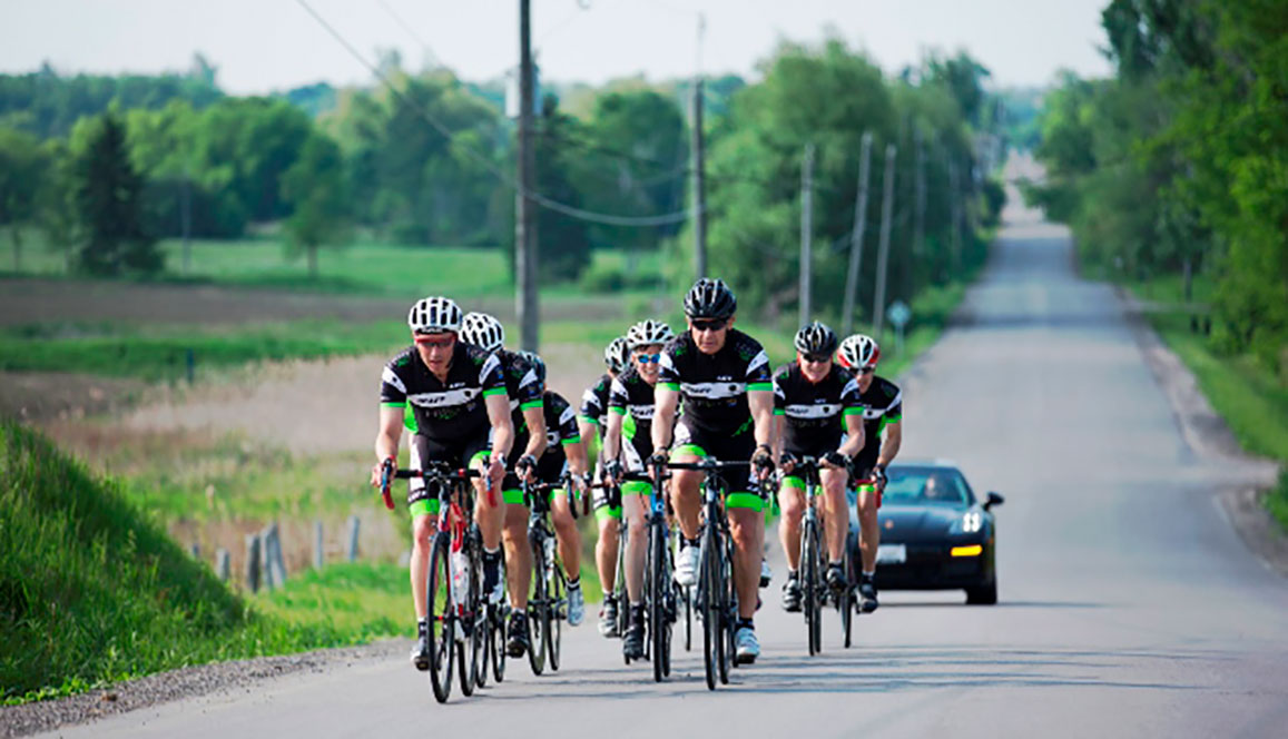 Cyclists riding bikes on country road