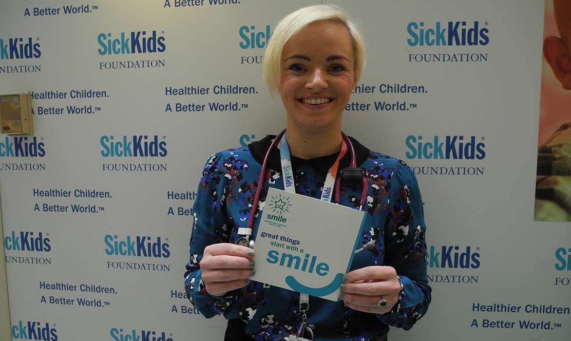 SickKids staff holding SMILE card