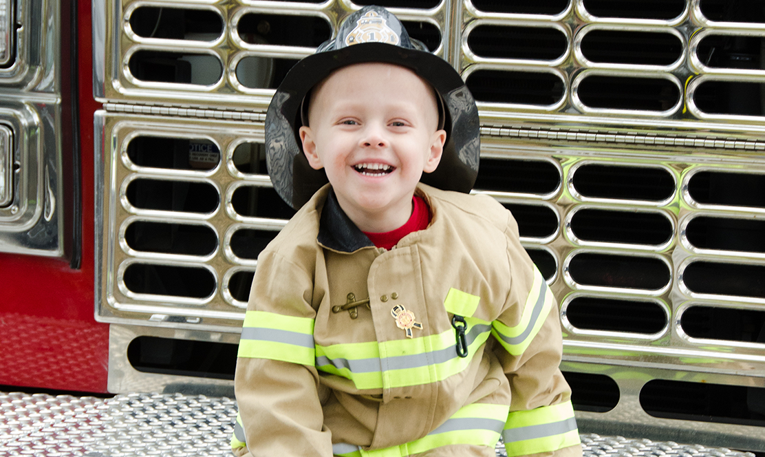 Little boy in firefighter uniform