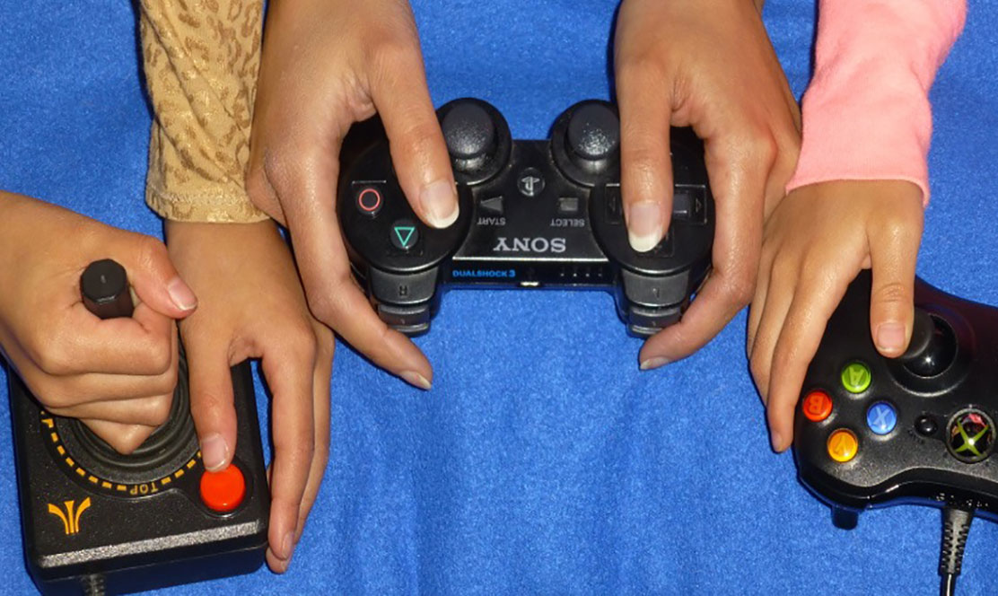 Hands holding remote controls for gaming consoles