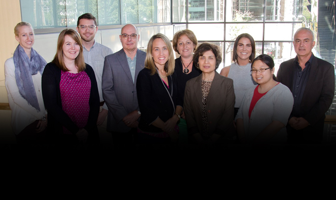 A group of adults dressed in business clothing standing together smiling at the camera