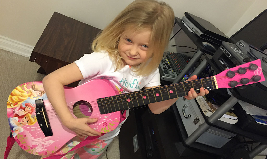 Little girl holding a guitar