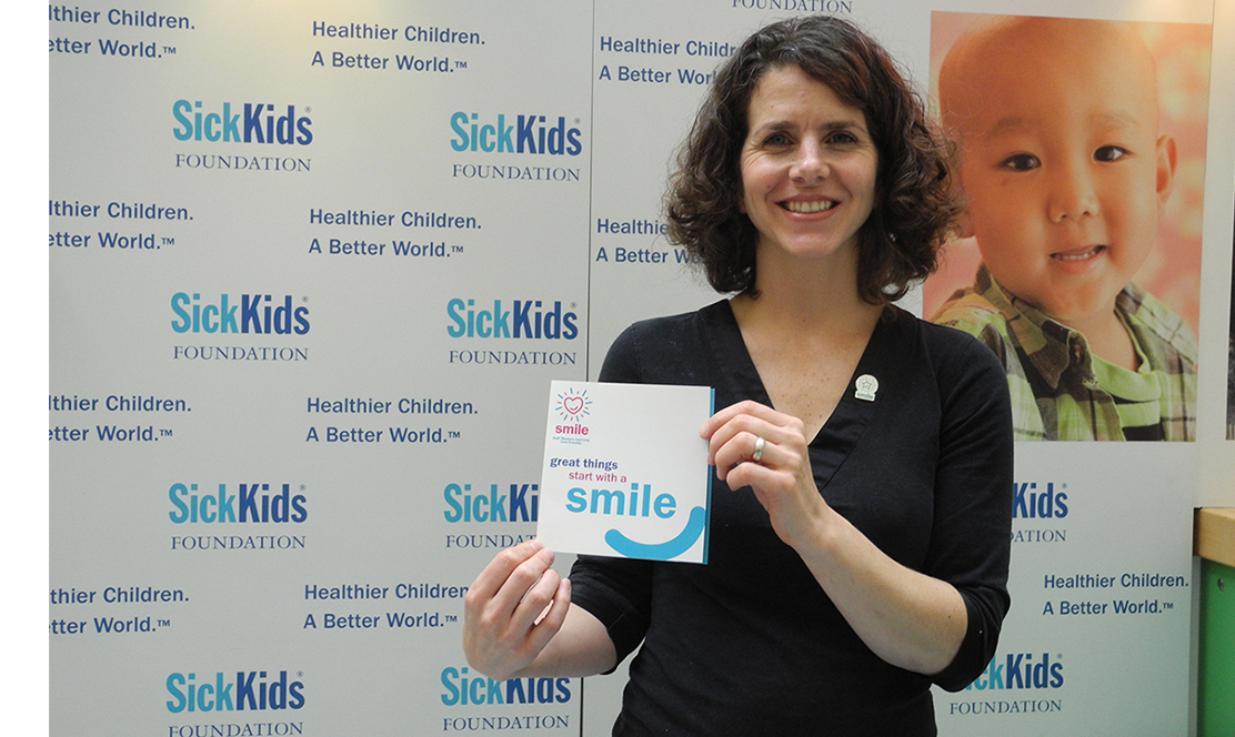 SickKids staff member holding SMILE card