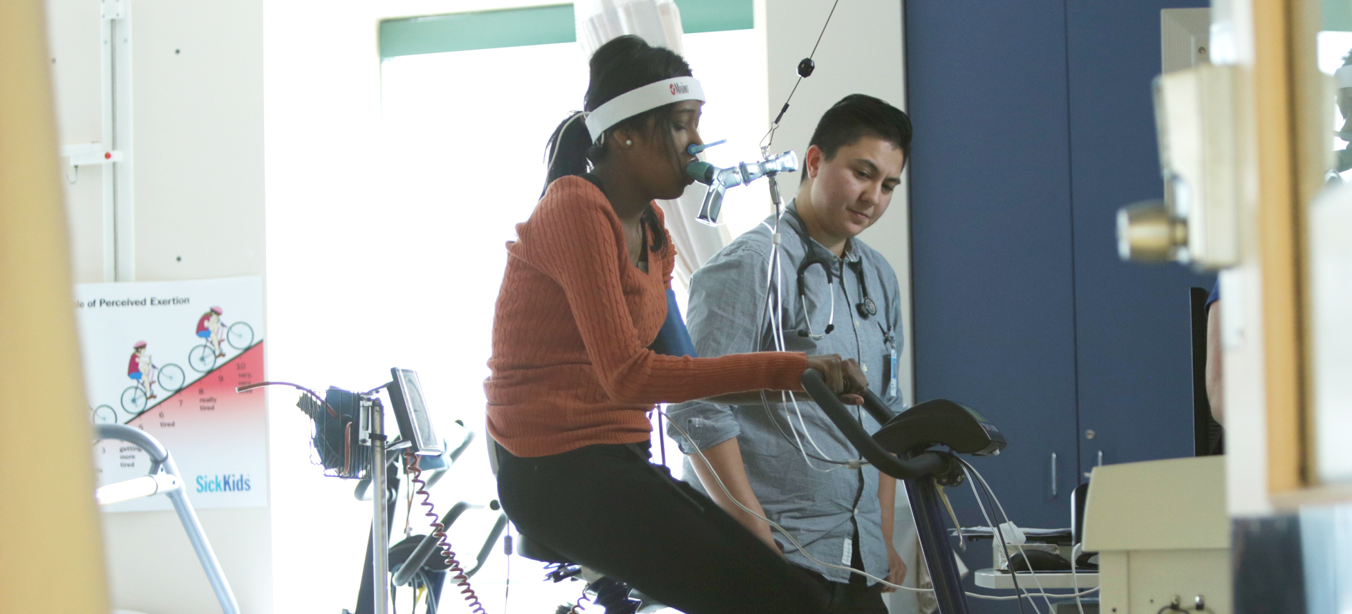 female teenage patient with breathing apparatus on stationary bike
