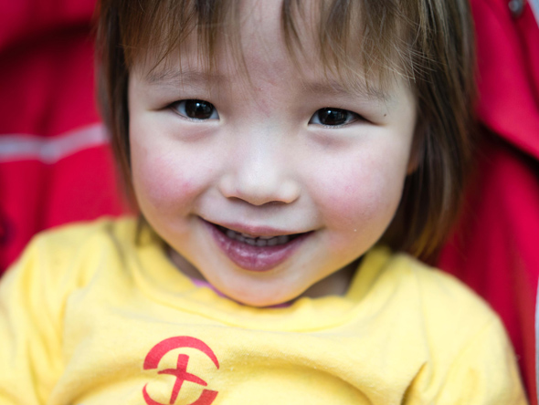 Little girl smiling in stroller