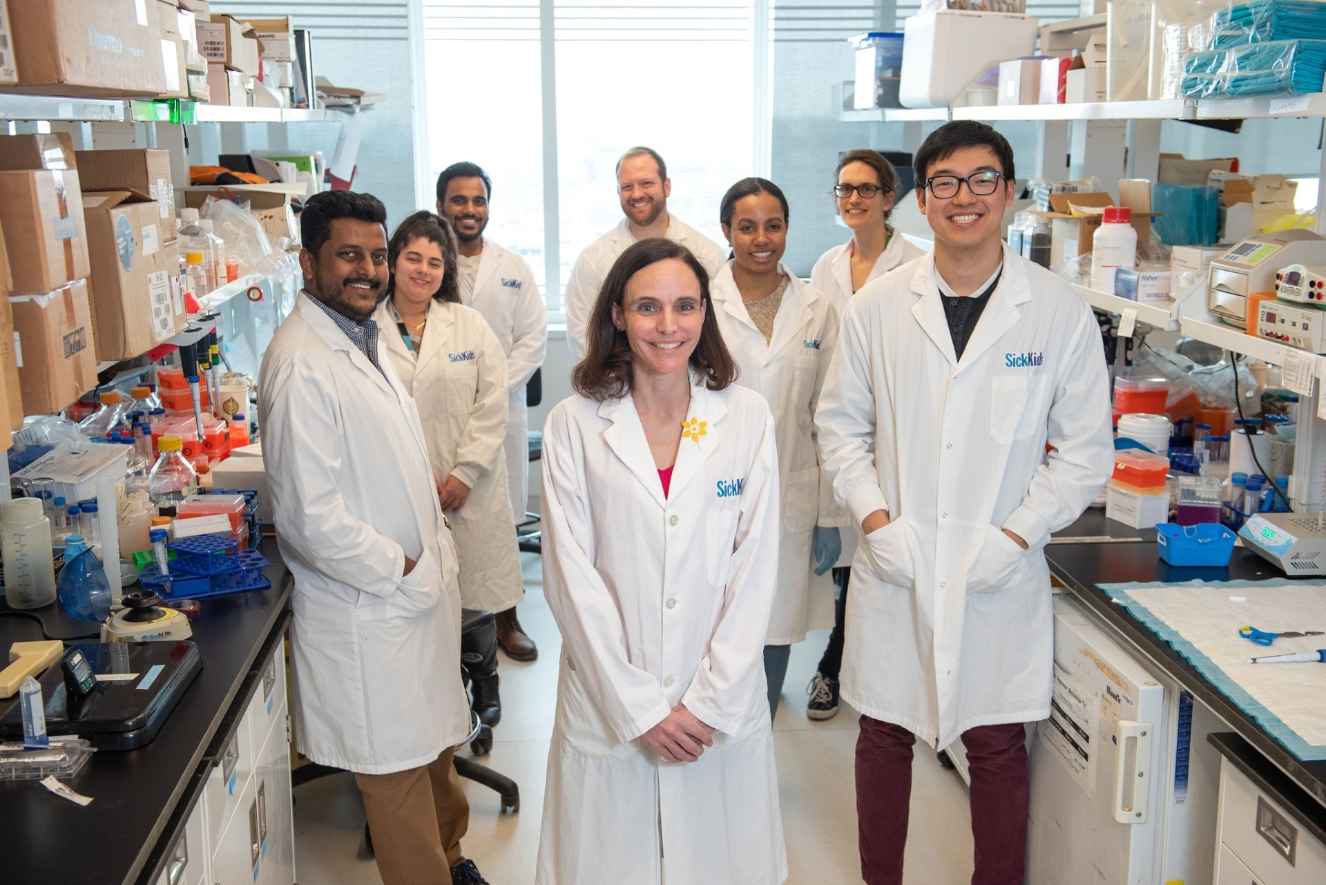 Dr Cynthia Hawkins surrounded by a team of researchers