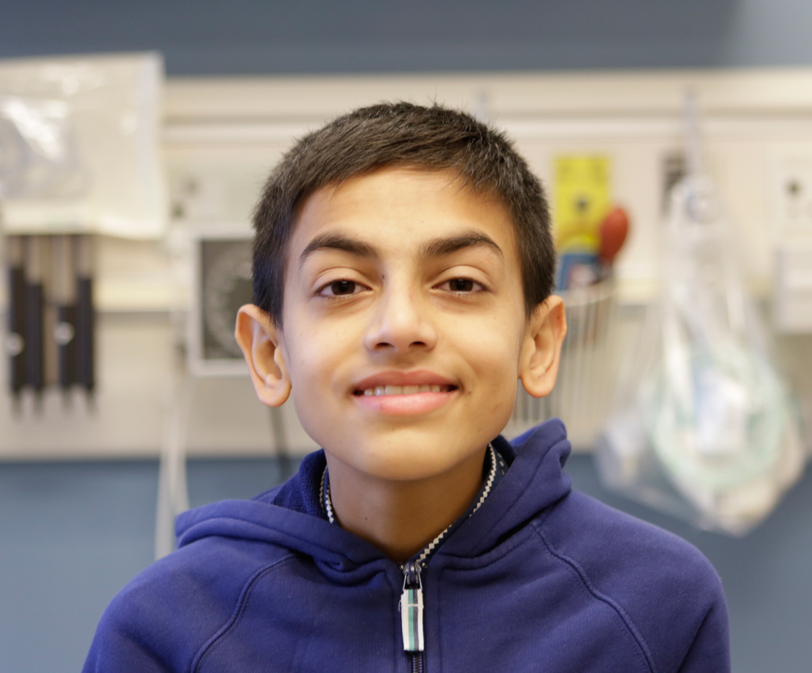Headshot of boy in blue hooded sweatshirt