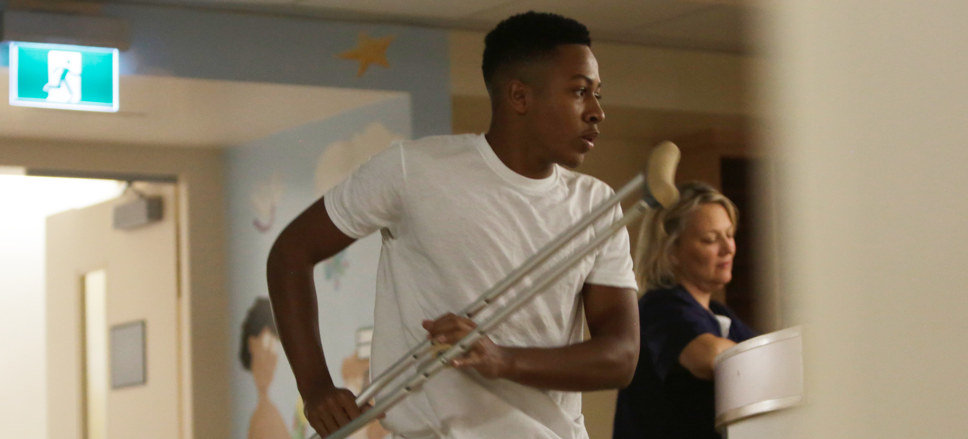 teenage boy holding crutches