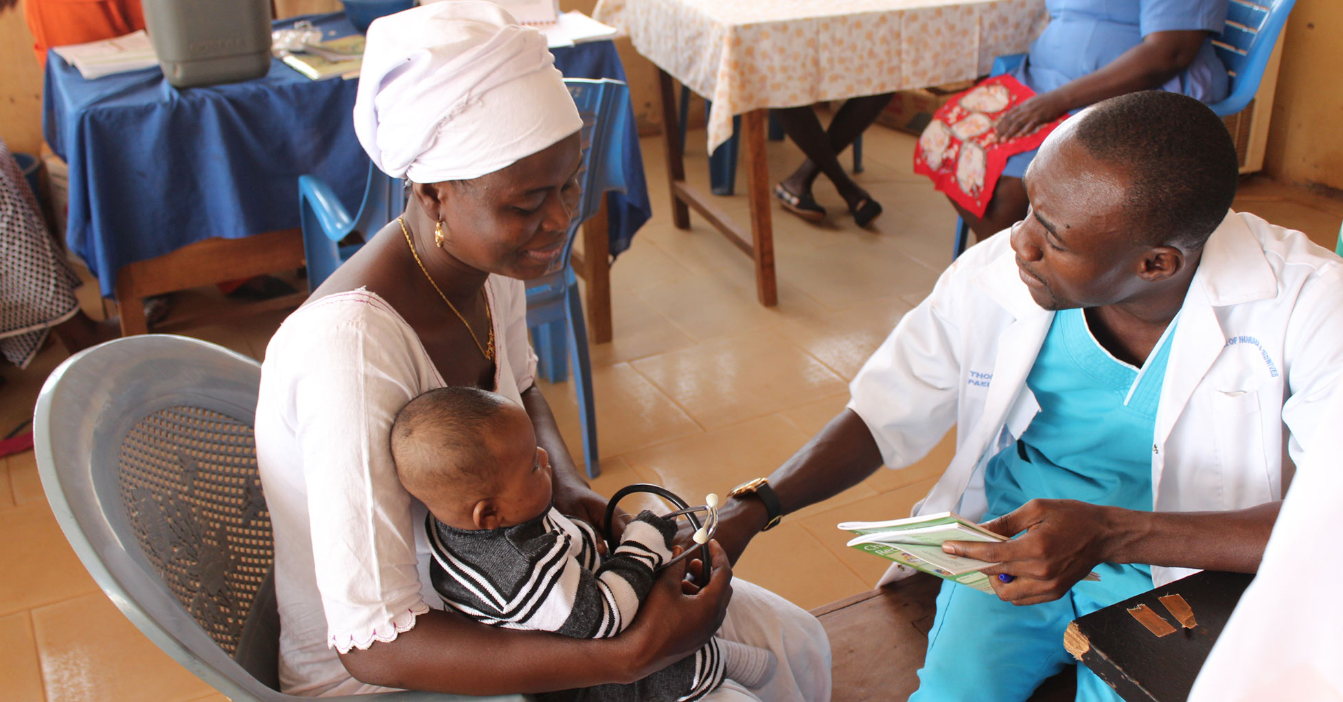 Mother holding baby in lap talking to doctor